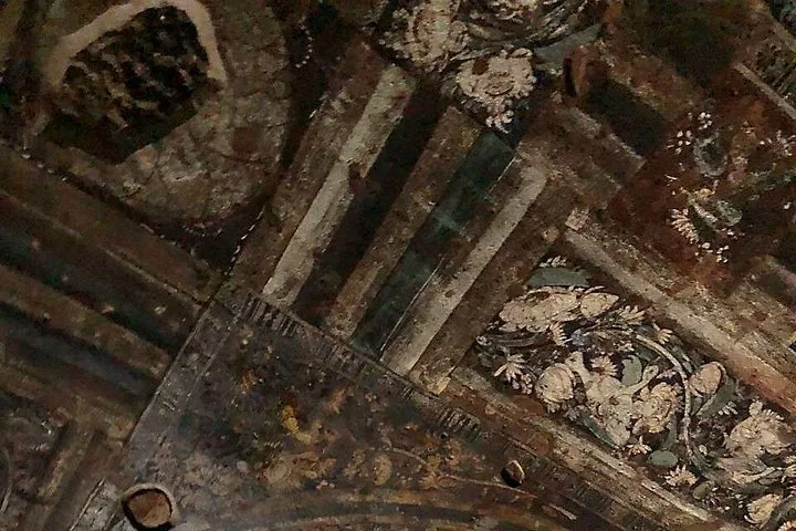 Detail of ancient ceiling frescoes showing floral and geometric designs at Ajanta Caves.