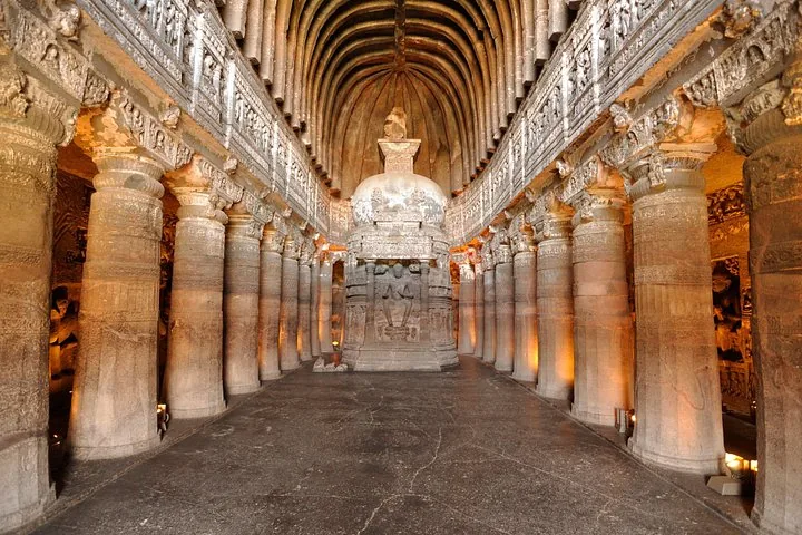 Majestic interior of a rock-cut chaitya hall with pillars and a central stupa.